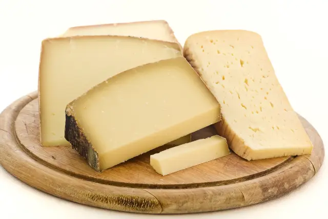 Morceaux de fromage Appenzeller sur une planche de bois.